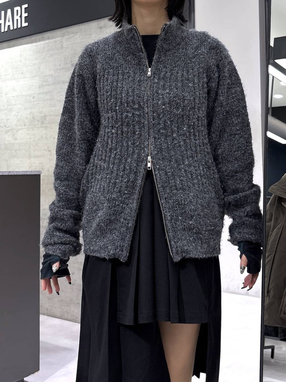 ブラック系のスカート、グレー系のカーディガン/ボレロ、ブラック系のベルトを着用したレディースの冬コーディネートの2枚目の写真