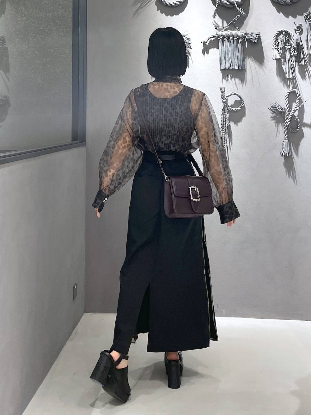 ブラック系のタンクトップ、ブラック系のサンダル、ブラウン系のショルダーバッグを着用したレディースの夏コーディネートの7枚目の写真