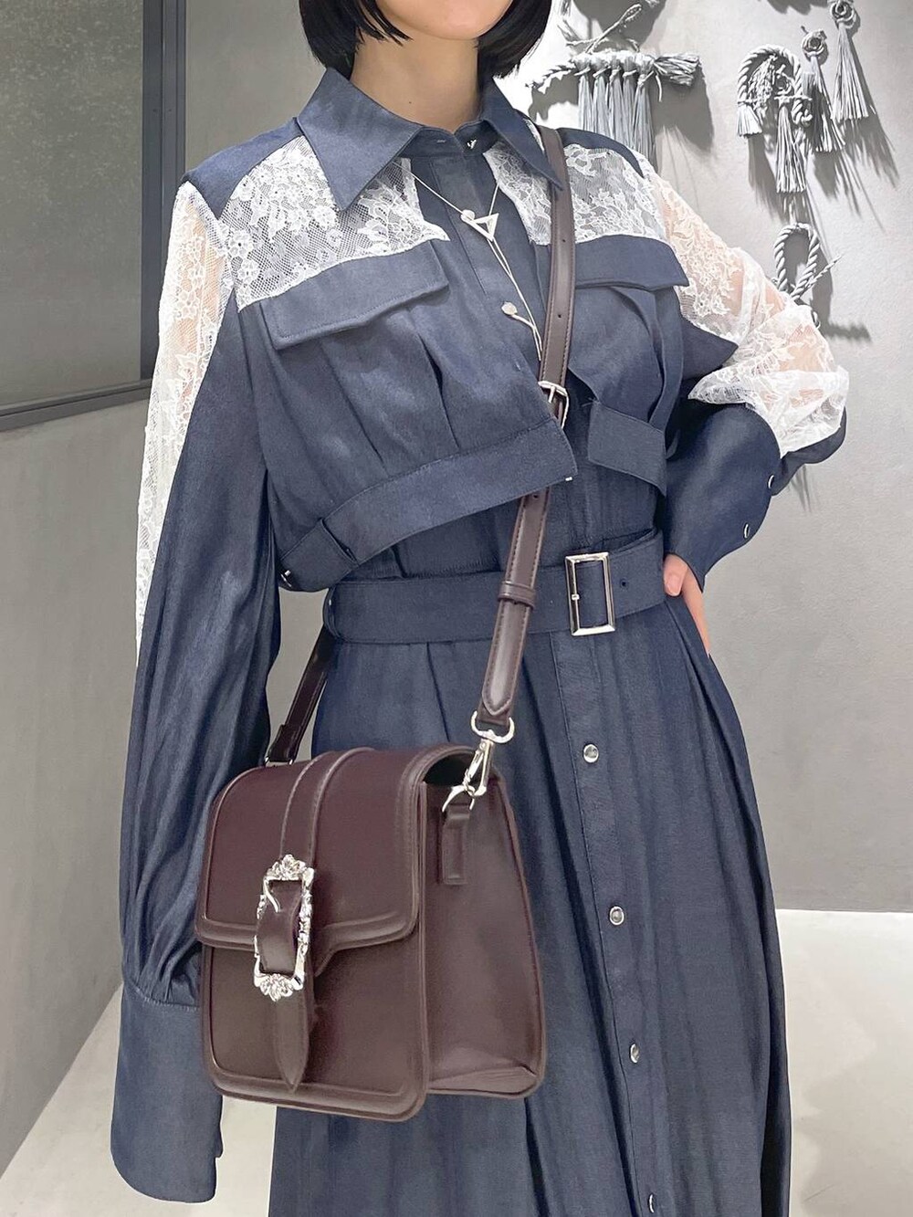 ブラック系のタンクトップ、ブラック系のサンダル、ブラウン系のショルダーバッグを着用したレディースの夏コーディネートの2枚目の写真