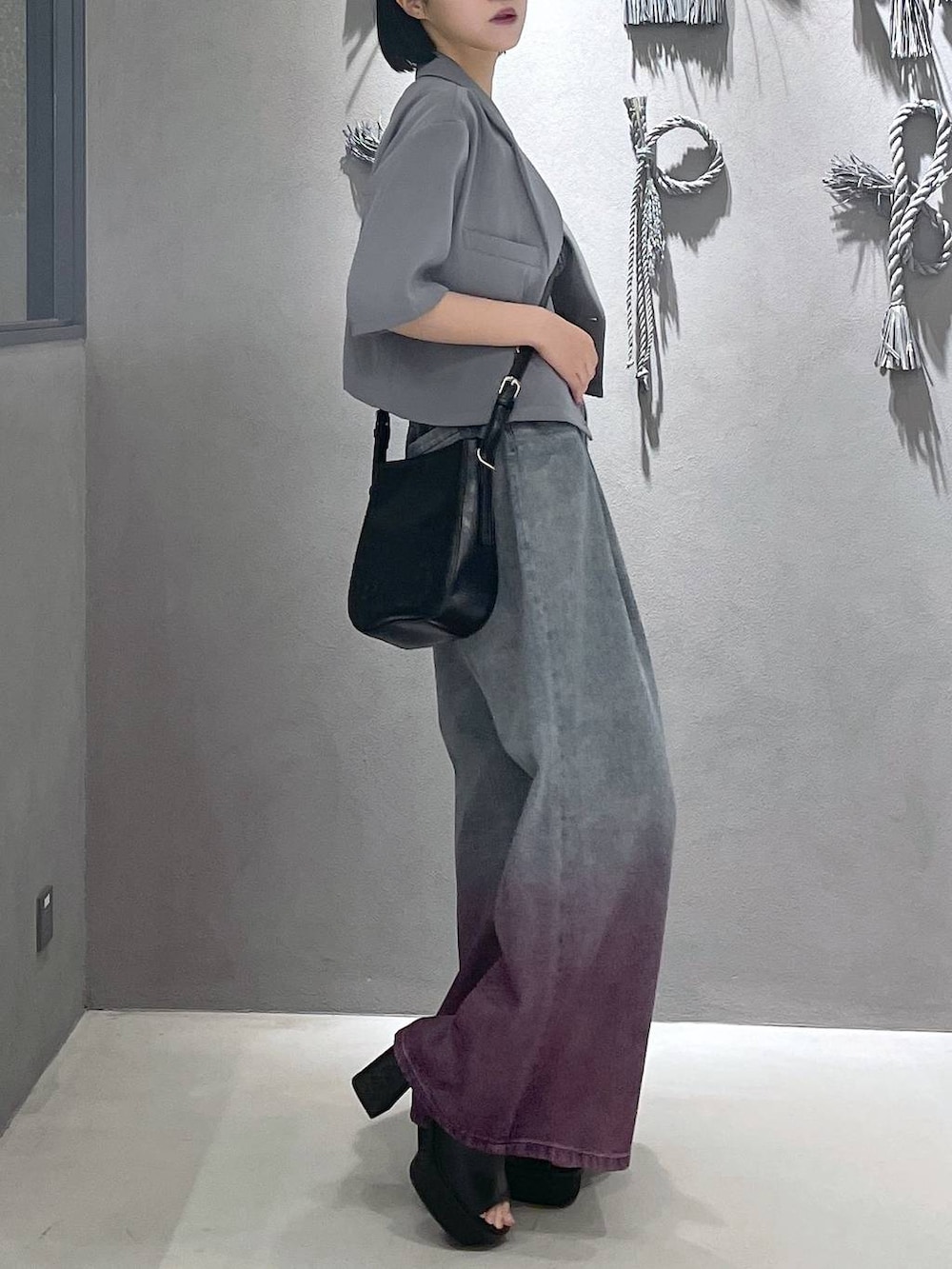 ブラック系のタンクトップ、ブラック系のサンダル、パープル系のデニムパンツを着用したレディースの夏コーディネートの4枚目の写真