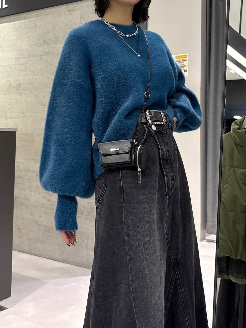 グレー系のタンクトップ、ブルー系のニット/セーター、ブラック系のブーツを着用したレディースの秋コーディネートの2枚目の写真