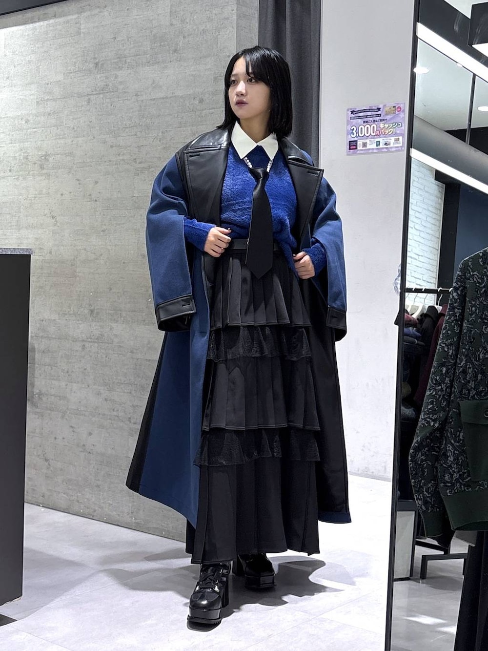 ブラック系のネクタイ、ブルー系のチェスターコート、ブルー系のニット/セーターを着用したレディースの冬コーディネートの5枚目の写真