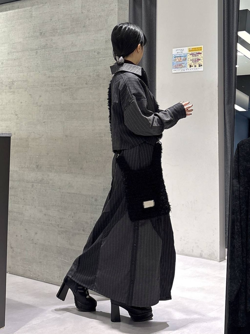 レッド系のニット/セーター、ブラック系のブーツ、ブラック系のショルダーバッグを着用したレディースの秋コーディネートの6枚目の写真