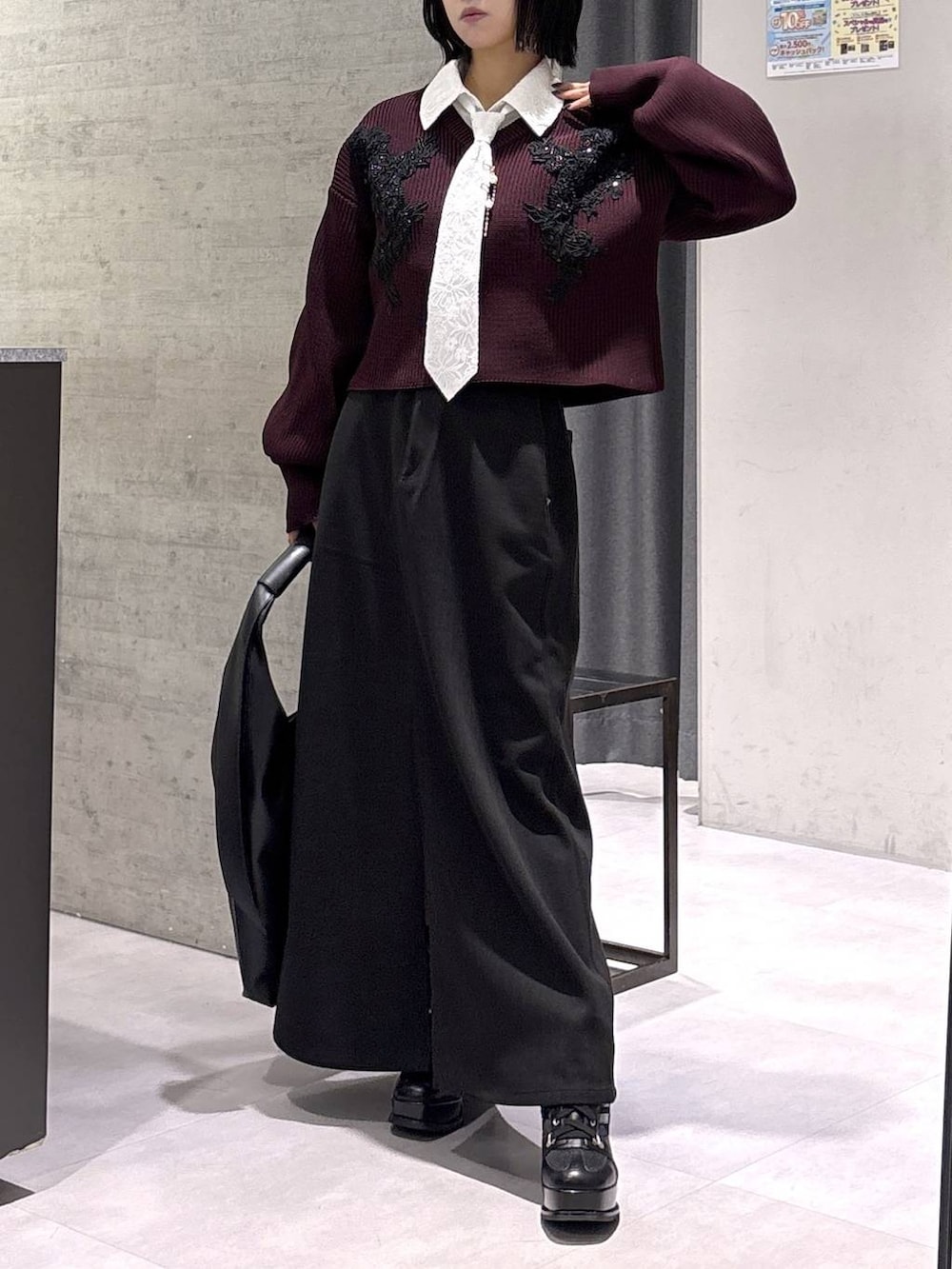 ブラック系のトートバッグ、ブラック系のブーツ、レッド系のニット/セーターを着用したレディースの秋コーディネートの4枚目の写真