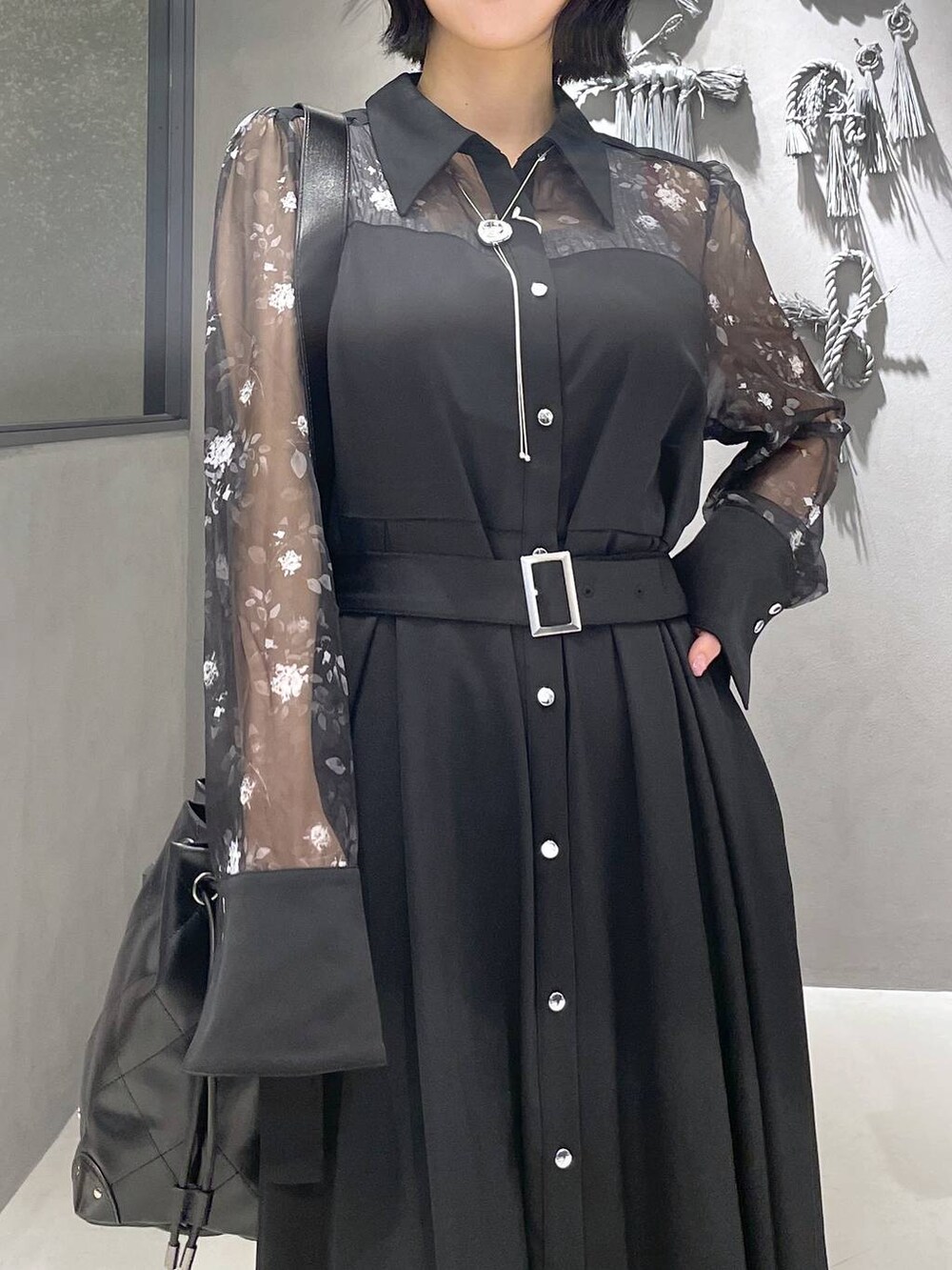 グレー系のタンクトップ、ブラック系のパンプス、ブラック系のショルダーバッグを着用したレディースの夏コーディネートの2枚目の写真