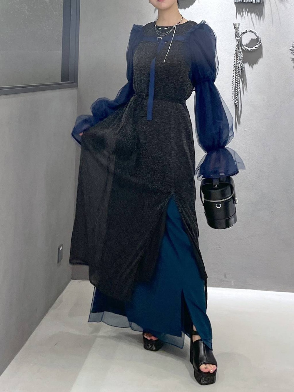 ブラック系のタンクトップ、グレー系のサンダル、ブラック系のショルダーバッグを着用したレディースの夏コーディネートの4枚目の写真