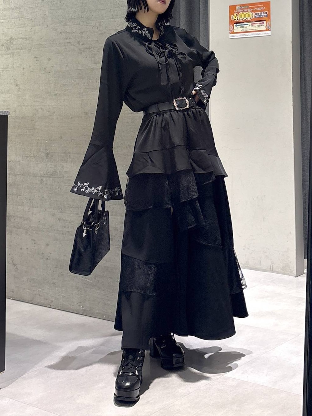 ブラック系のショルダーバッグ、ブラック系のシャツ/ブラウス、ブラック系のブーツを着用したレディースの秋コーディネートの9枚目の写真