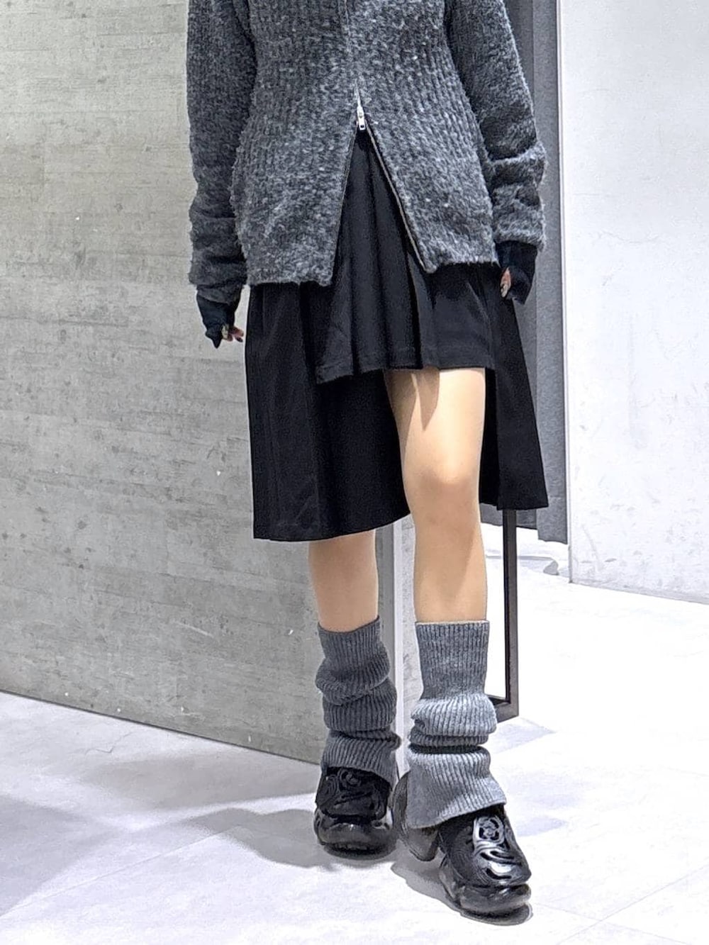 ブラック系のスカート、グレー系のカーディガン/ボレロ、ブラック系のベルトを着用したレディースの冬コーディネートの3枚目の写真