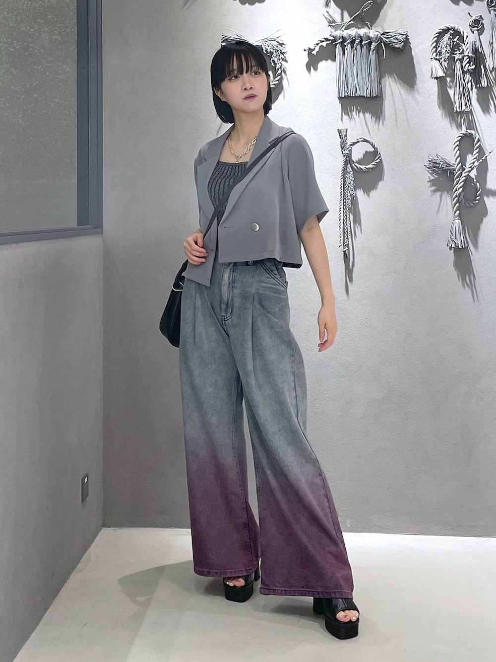 ブラック系のタンクトップ、ブラック系のサンダル、パープル系のデニムパンツを着用したレディースの夏コーディネートの5枚目の写真