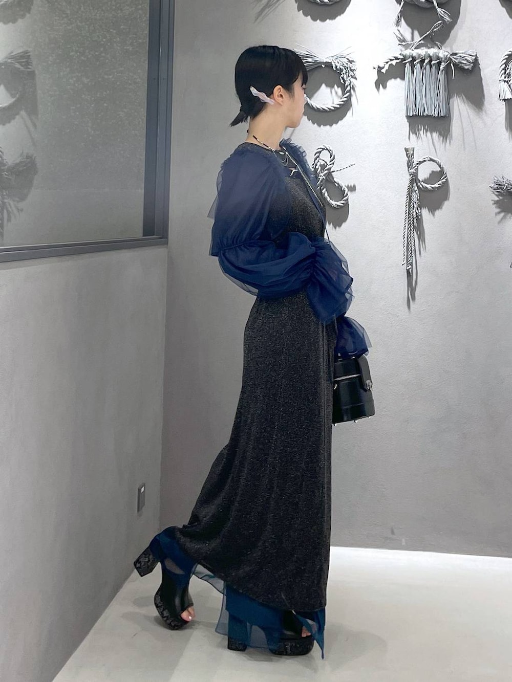 ブラック系のタンクトップ、グレー系のサンダル、ブラック系のショルダーバッグを着用したレディースの夏コーディネートの6枚目の写真