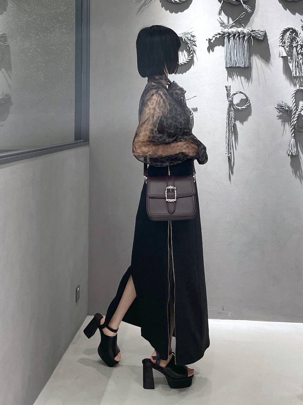 ブラック系のタンクトップ、ブラック系のサンダル、ブラウン系のショルダーバッグを着用したレディースの夏コーディネートの6枚目の写真