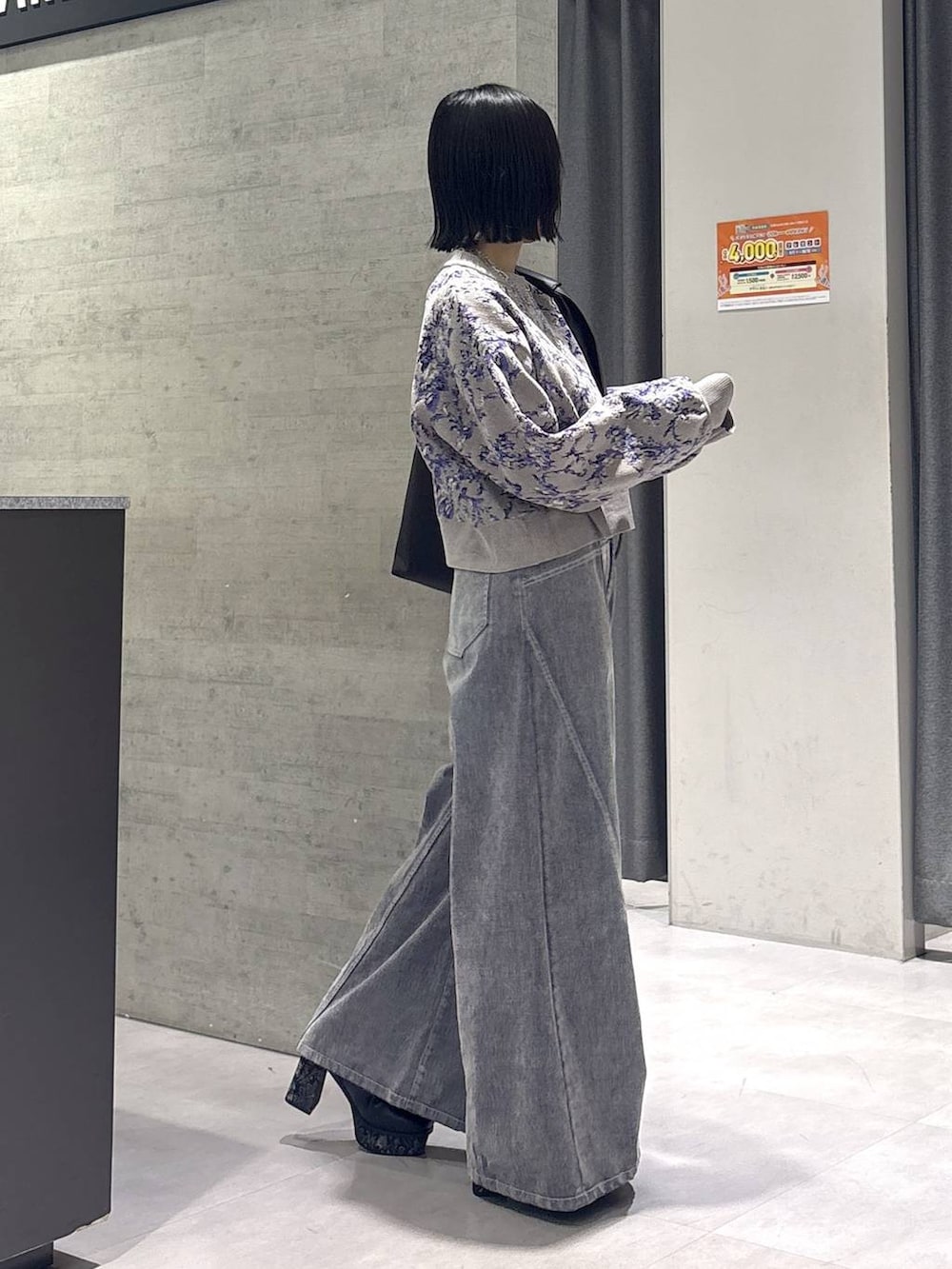 グレー系のタンクトップ、ブラック系のトートバッグ、グレー系のブーツを着用したレディースの秋コーディネートの6枚目の写真