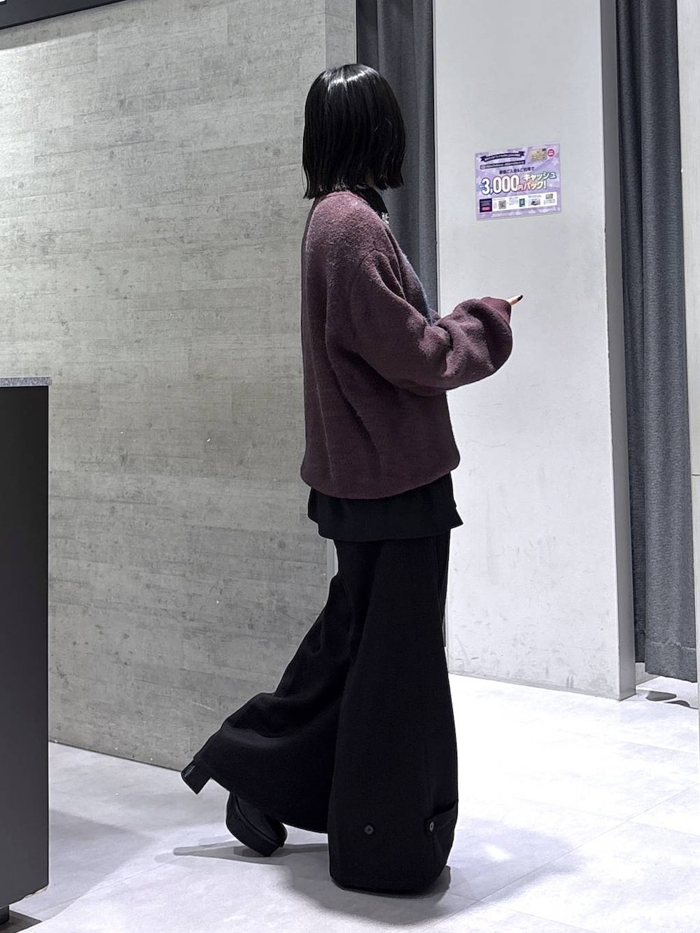 ブラック系のブーツ、レッド系のニット/セーター、ブラック系のスラックスを着用したレディースの秋コーディネートの6枚目の写真