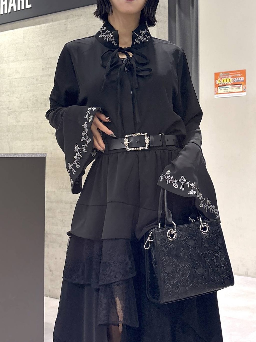 ブラック系のショルダーバッグ、ブラック系のシャツ/ブラウス、ブラック系のブーツを着用したレディースの秋コーディネートの2枚目の写真