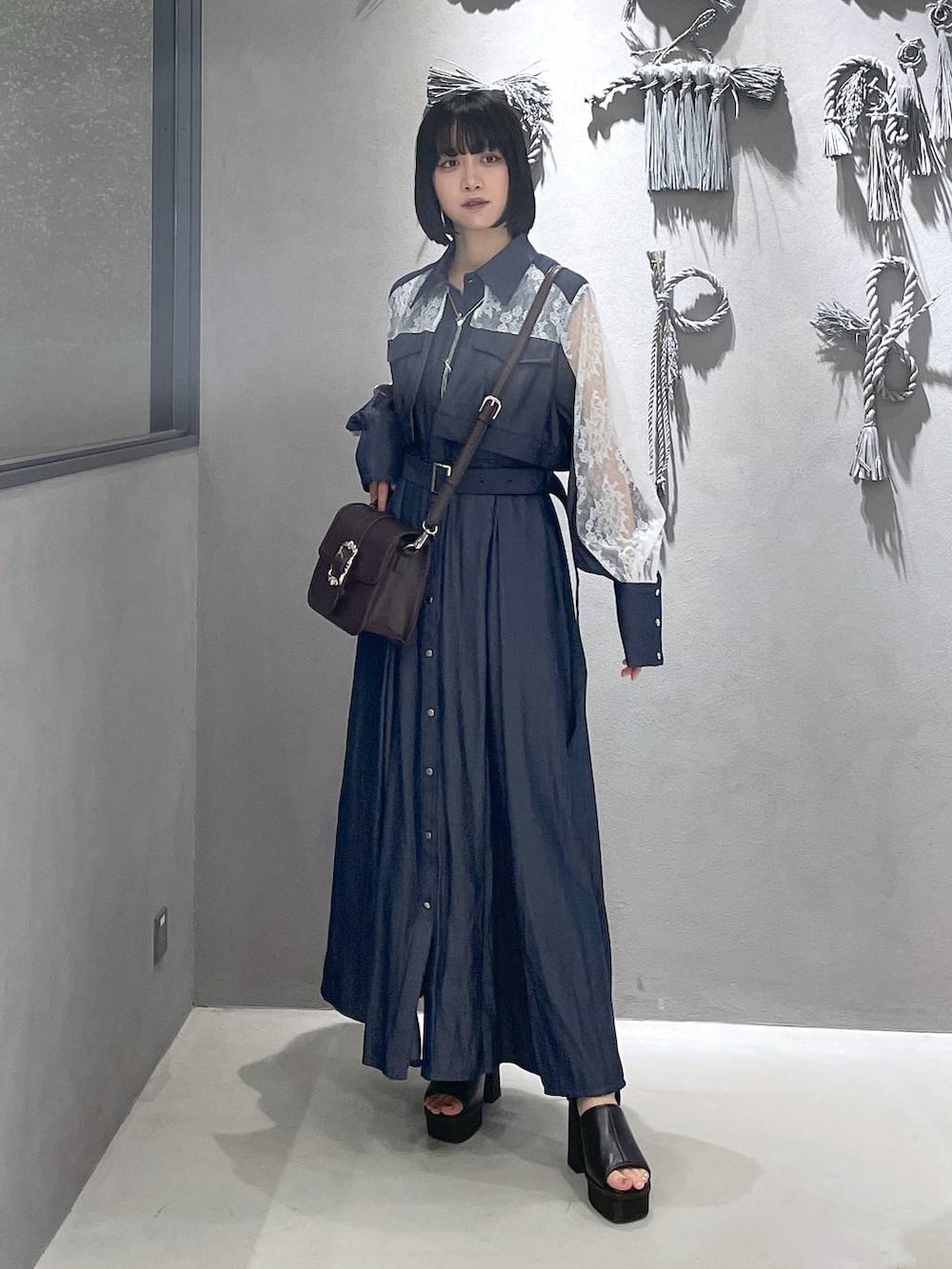 ブラック系のタンクトップ、ブラック系のサンダル、ブラウン系のショルダーバッグを着用したレディースの夏コーディネートの5枚目の写真