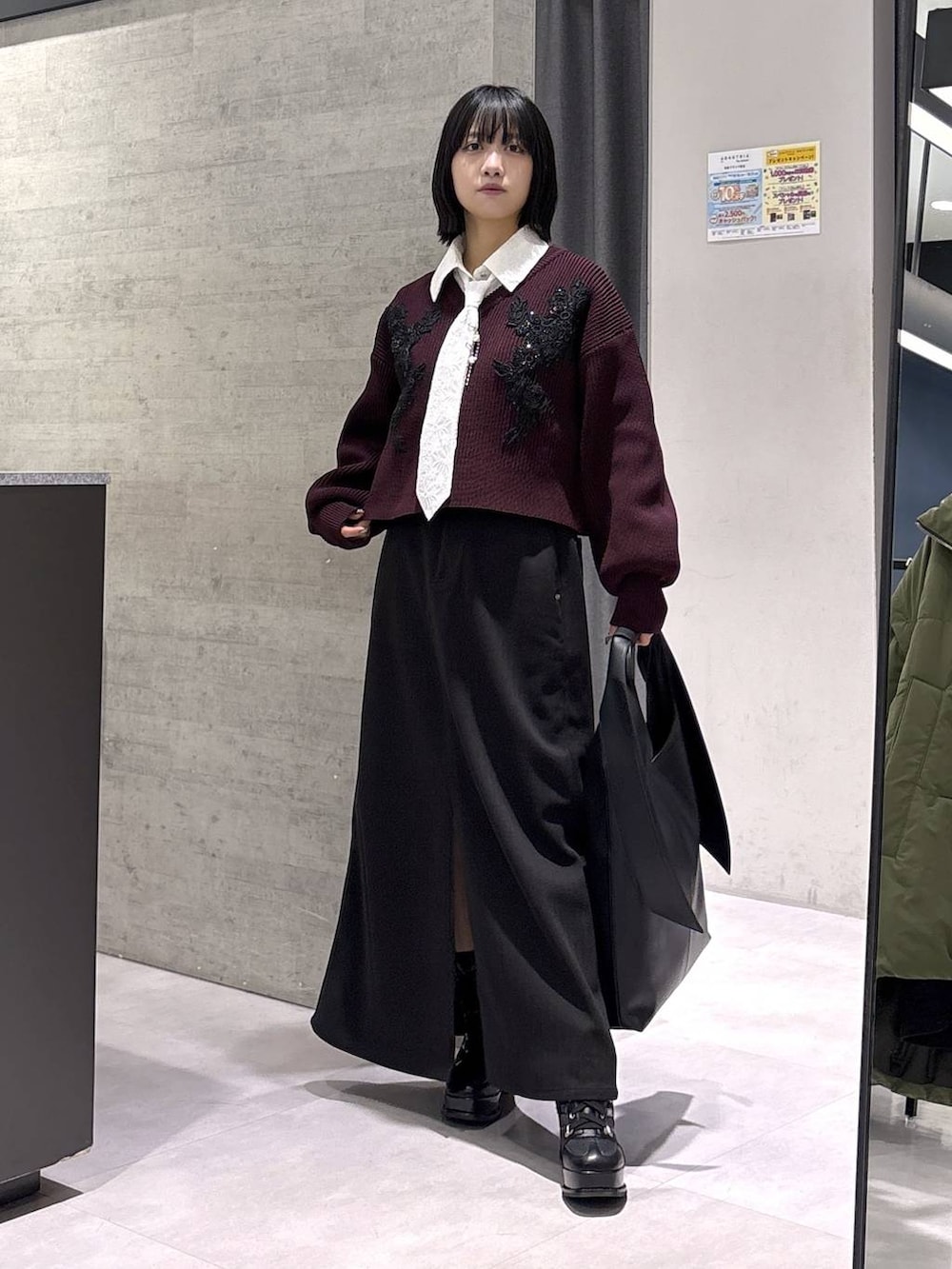 ブラック系のトートバッグ、ブラック系のブーツ、レッド系のニット/セーターを着用したレディースの秋コーディネートの5枚目の写真