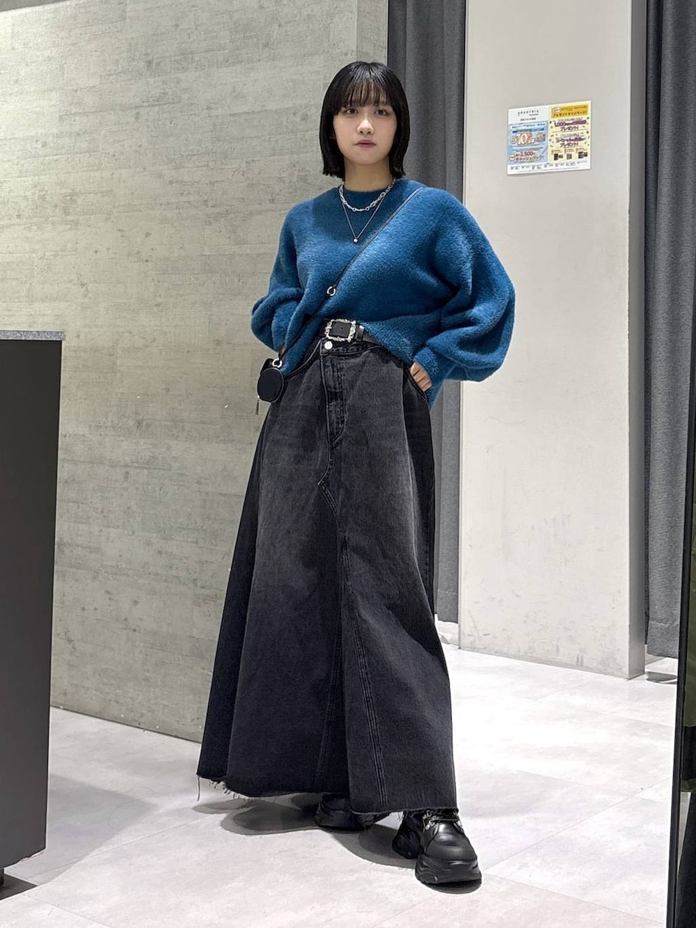 グレー系のタンクトップ、ブルー系のニット/セーター、ブラック系のブーツを着用したレディースの秋コーディネートの5枚目の写真