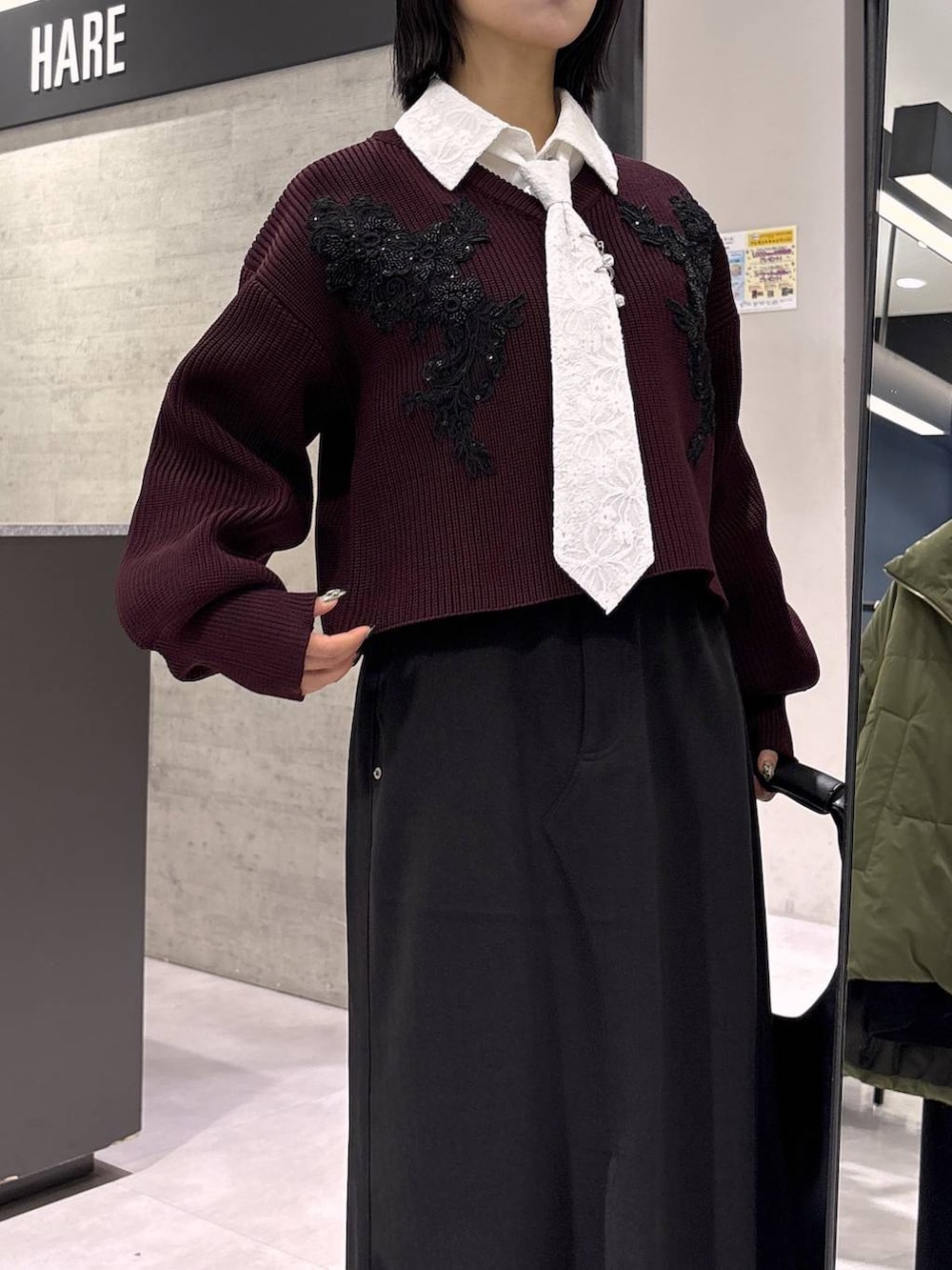 ブラック系のトートバッグ、ブラック系のブーツ、レッド系のニット/セーターを着用したレディースの秋コーディネートの2枚目の写真