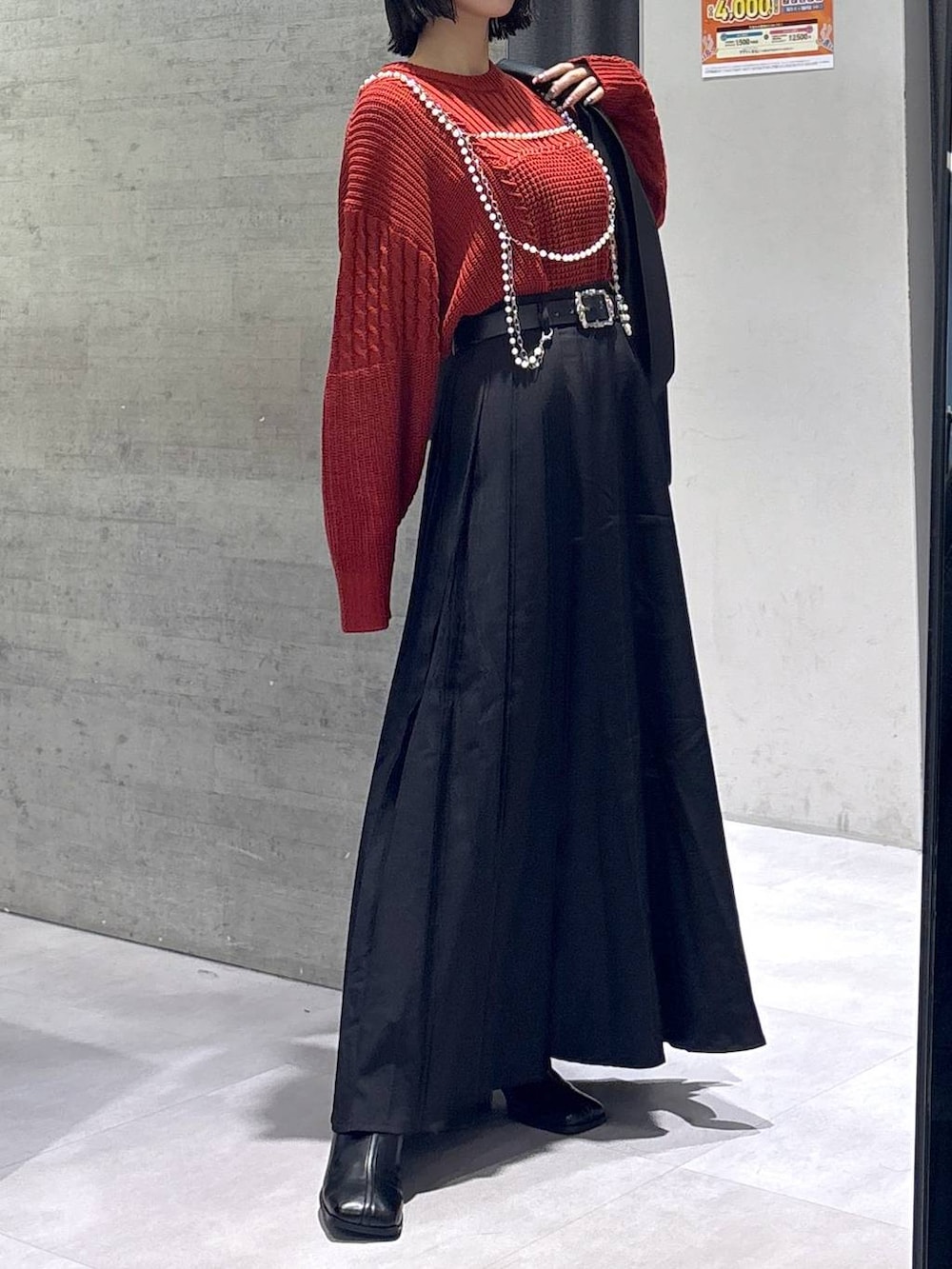 ブラック系のタンクトップ、ブラック系のトートバッグ、ブラック系のブーツを着用したレディースの秋コーディネートの4枚目の写真