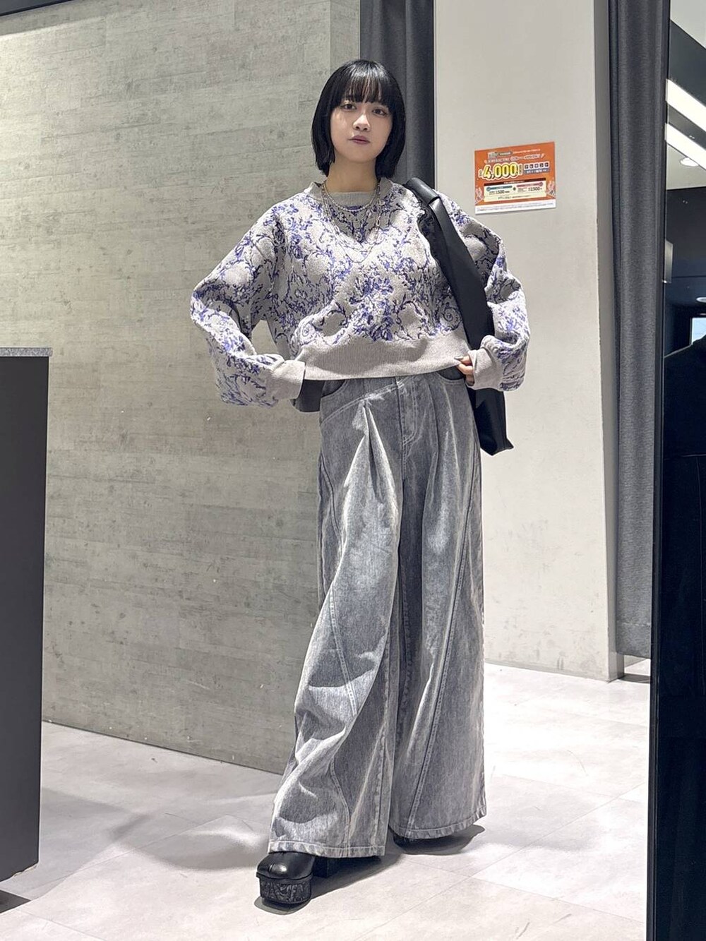 グレー系のタンクトップ、ブラック系のトートバッグ、グレー系のブーツを着用したレディースの秋コーディネートの5枚目の写真