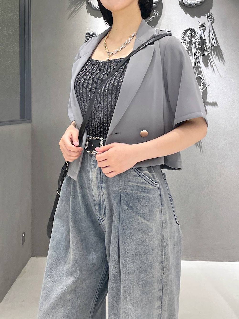 ブラック系のタンクトップ、ブラック系のサンダル、パープル系のデニムパンツを着用したレディースの夏コーディネートの8枚目の写真