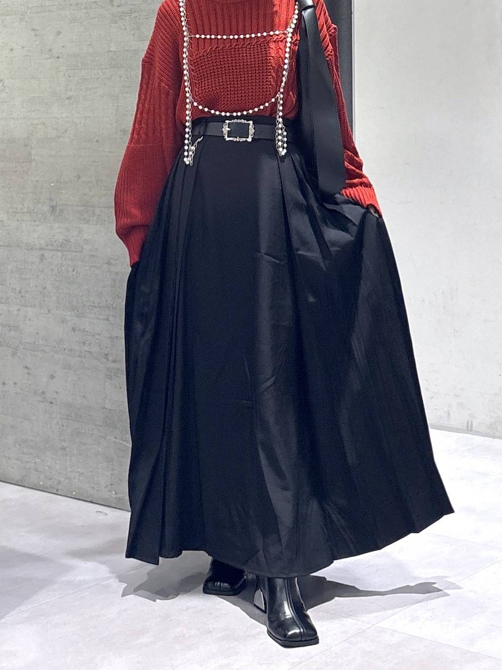 ブラック系のタンクトップ、ブラック系のトートバッグ、ブラック系のブーツを着用したレディースの秋コーディネートの3枚目の写真