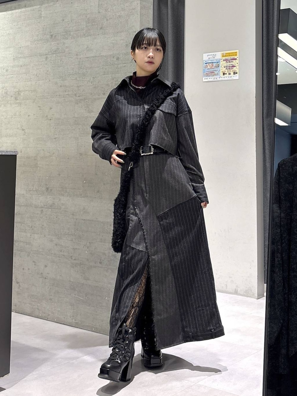 レッド系のニット/セーター、ブラック系のブーツ、ブラック系のショルダーバッグを着用したレディースの秋コーディネートの5枚目の写真