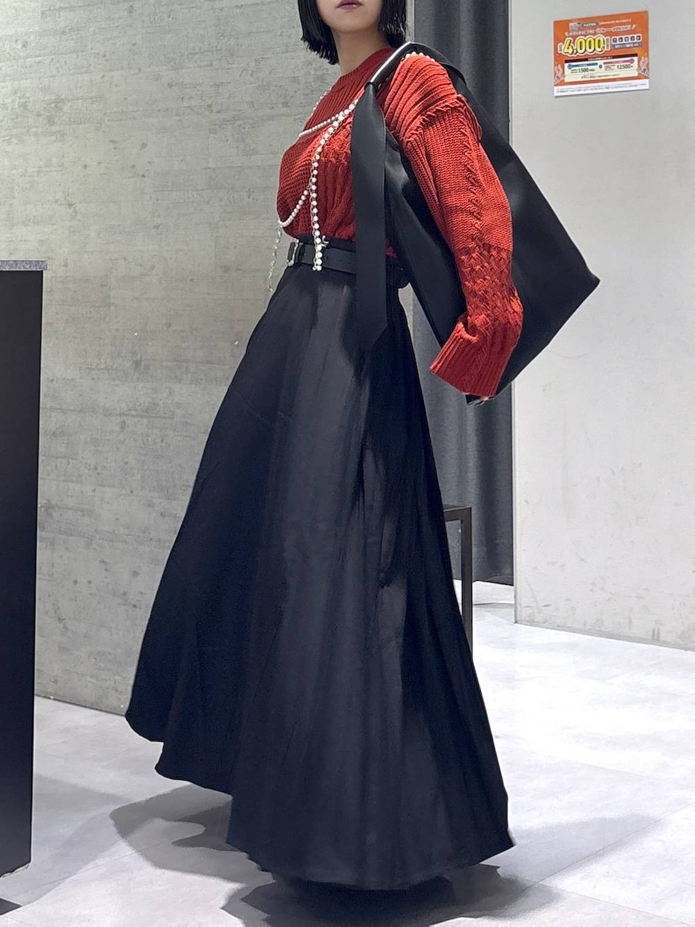 ブラック系のタンクトップ、ブラック系のトートバッグ、ブラック系のブーツを着用したレディースの秋コーディネートの9枚目の写真