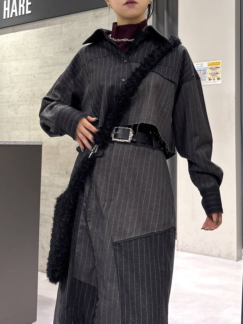 レッド系のニット/セーター、ブラック系のブーツ、ブラック系のショルダーバッグを着用したレディースの秋コーディネートの2枚目の写真