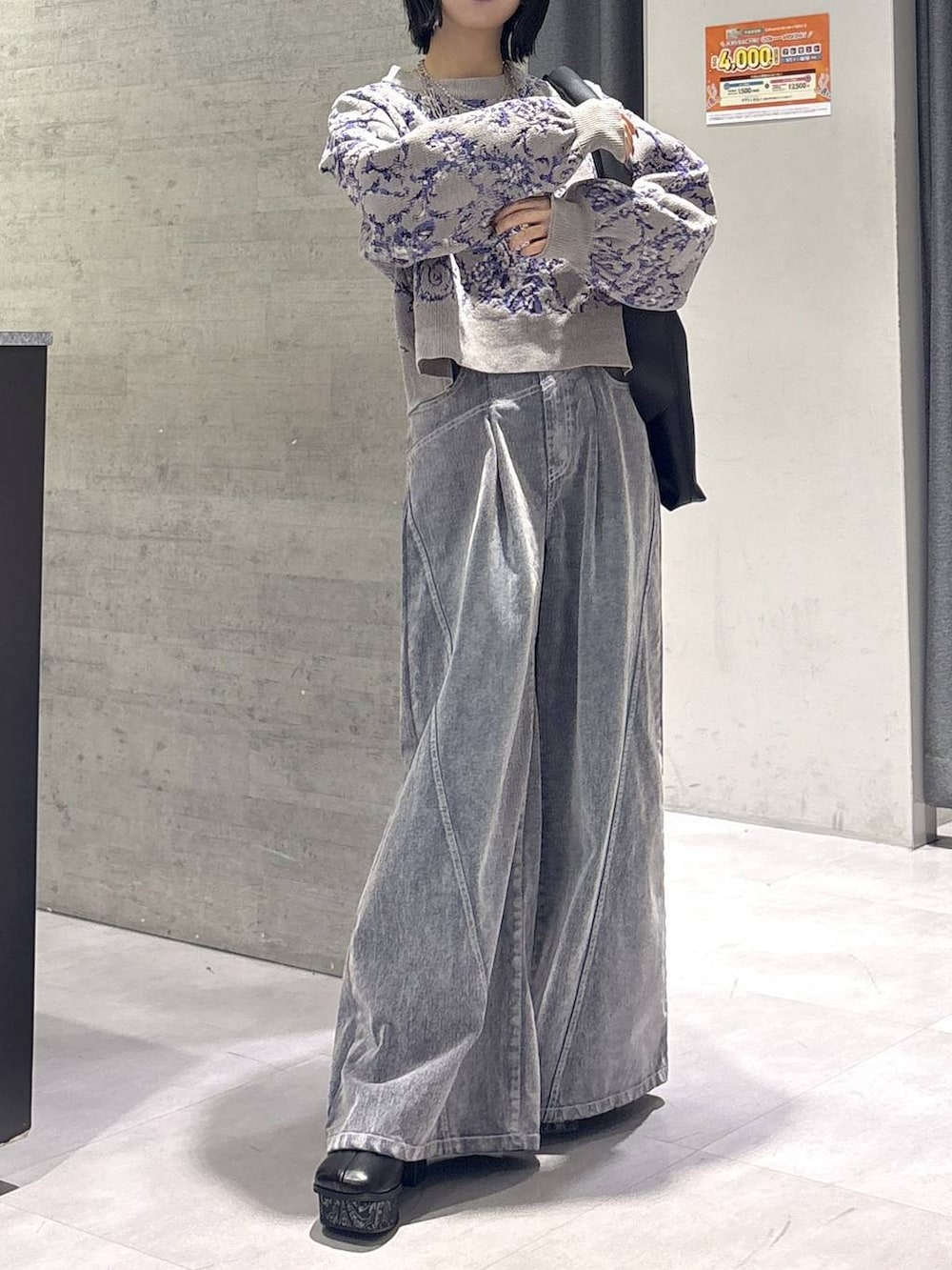 グレー系のタンクトップ、ブラック系のトートバッグ、グレー系のブーツを着用したレディースの秋コーディネートの9枚目の写真