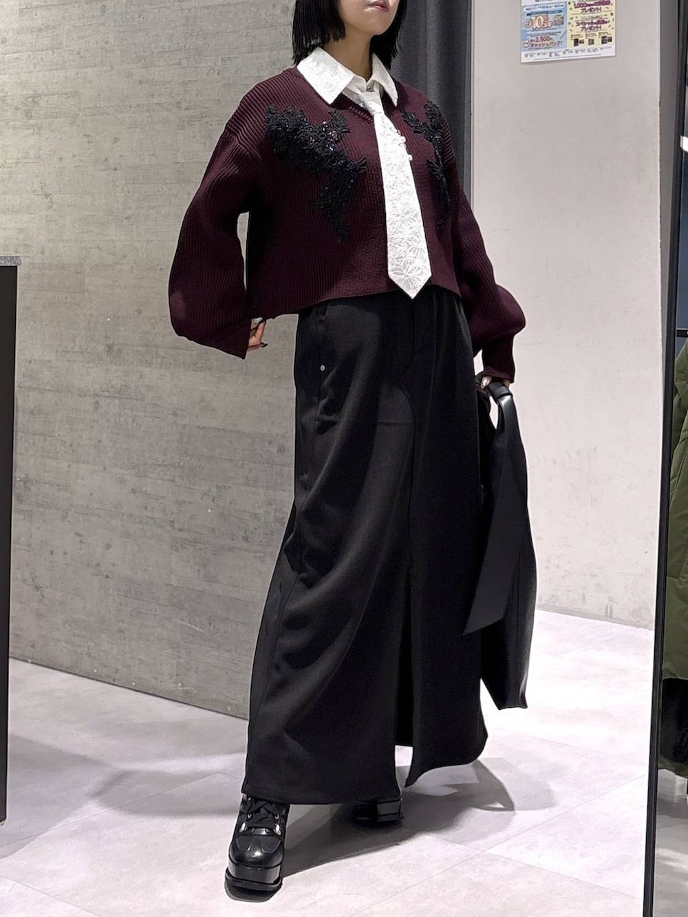 ブラック系のトートバッグ、ブラック系のブーツ、レッド系のニット/セーターを着用したレディースの秋コーディネートの9枚目の写真