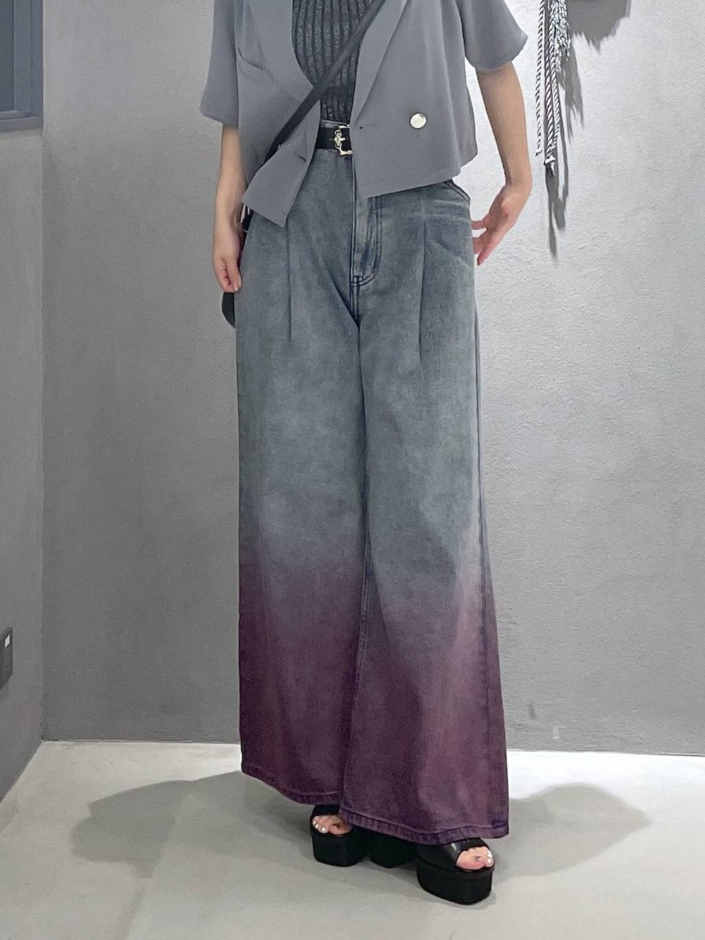 ブラック系のタンクトップ、ブラック系のサンダル、パープル系のデニムパンツを着用したレディースの夏コーディネートの3枚目の写真