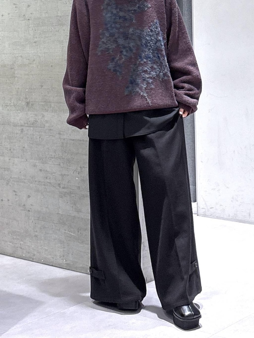 ブラック系のブーツ、レッド系のニット/セーター、ブラック系のスラックスを着用したレディースの秋コーディネートの3枚目の写真