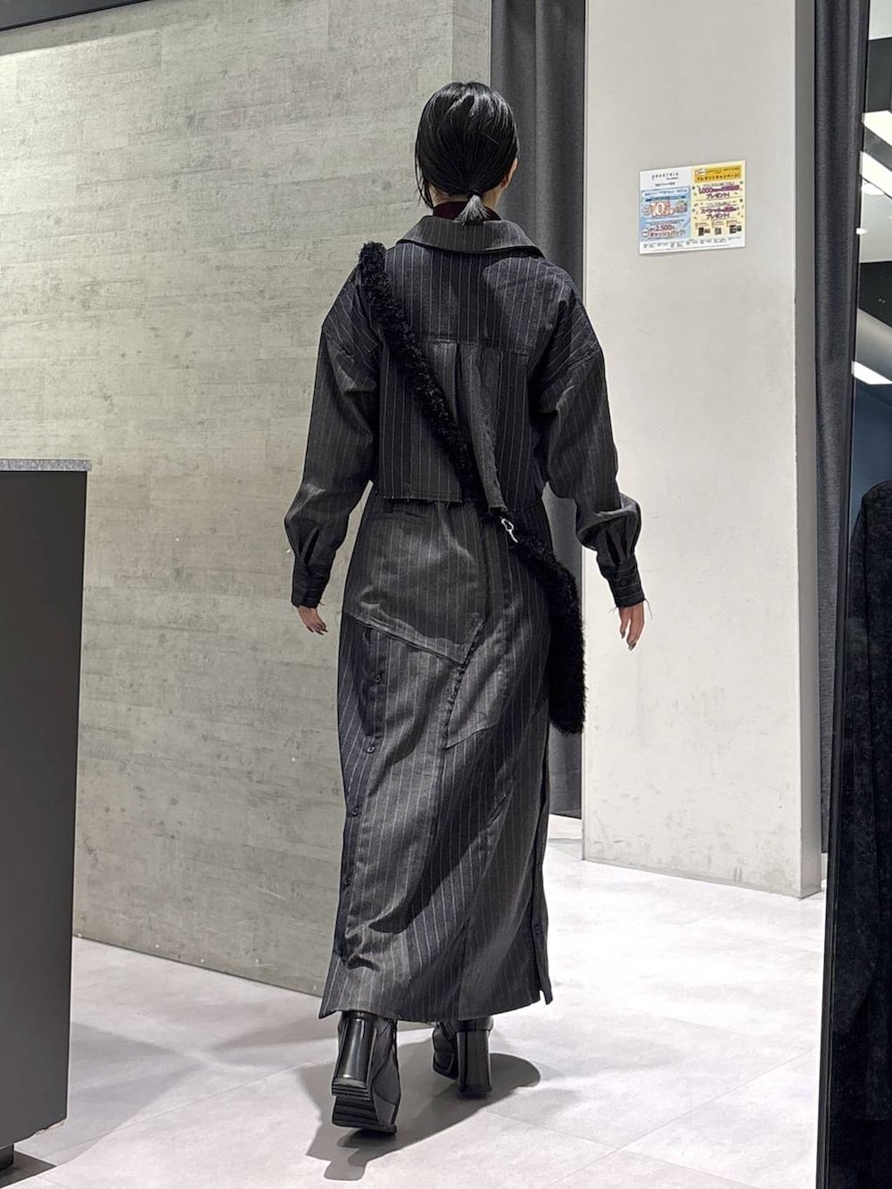 レッド系のニット/セーター、ブラック系のブーツ、ブラック系のショルダーバッグを着用したレディースの秋コーディネートの7枚目の写真