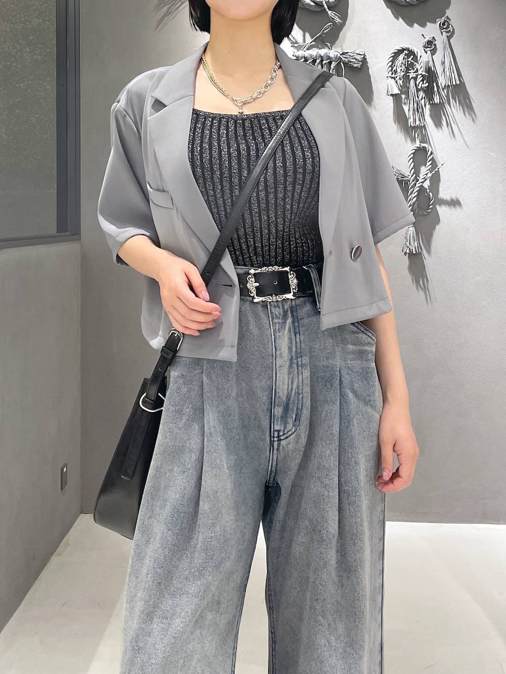 ブラック系のタンクトップ、ブラック系のサンダル、パープル系のデニムパンツを着用したレディースの夏コーディネートの2枚目の写真