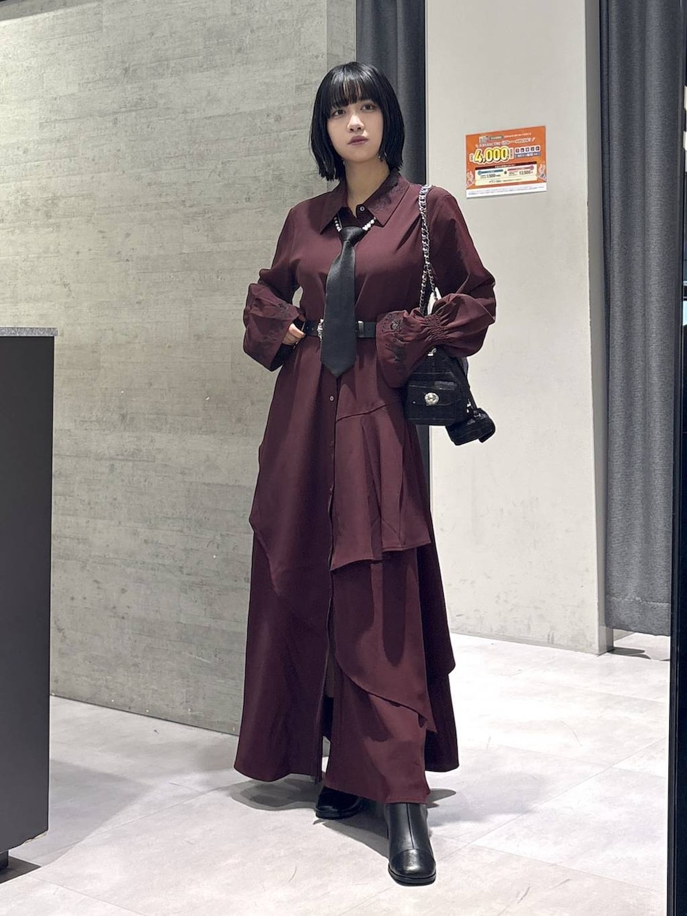 ブラック系のネクタイ、グレー系のタンクトップ、ブラック系のブーツを着用したレディースの秋コーディネートの5枚目の写真