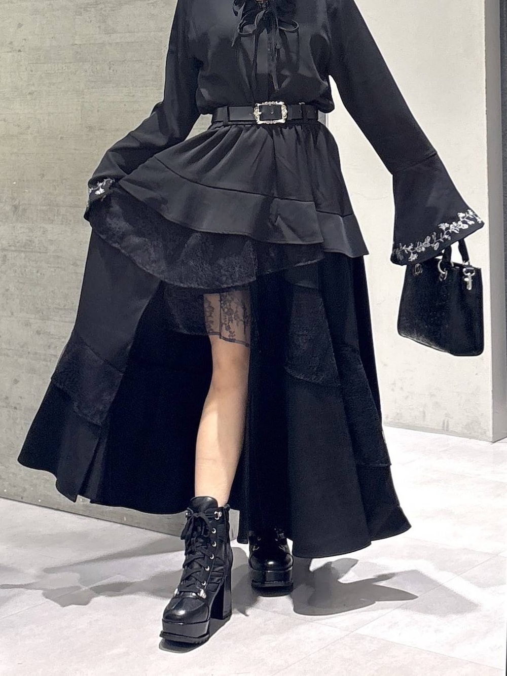 ブラック系のショルダーバッグ、ブラック系のシャツ/ブラウス、ブラック系のブーツを着用したレディースの秋コーディネートの3枚目の写真