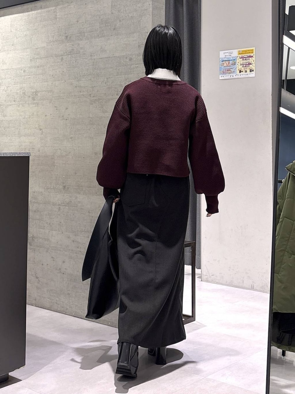 ブラック系のトートバッグ、ブラック系のブーツ、レッド系のニット/セーターを着用したレディースの秋コーディネートの7枚目の写真