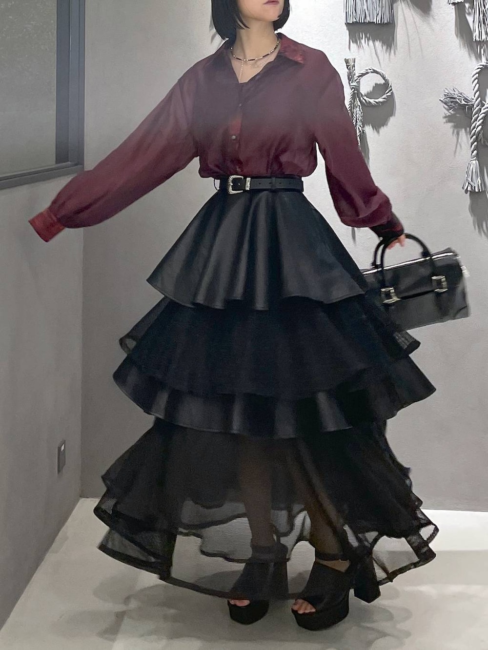 ブラック系のタンクトップ、ブラック系のサンダル、ブラック系のボストンバッグを着用したレディースの夏コーディネートの4枚目の写真