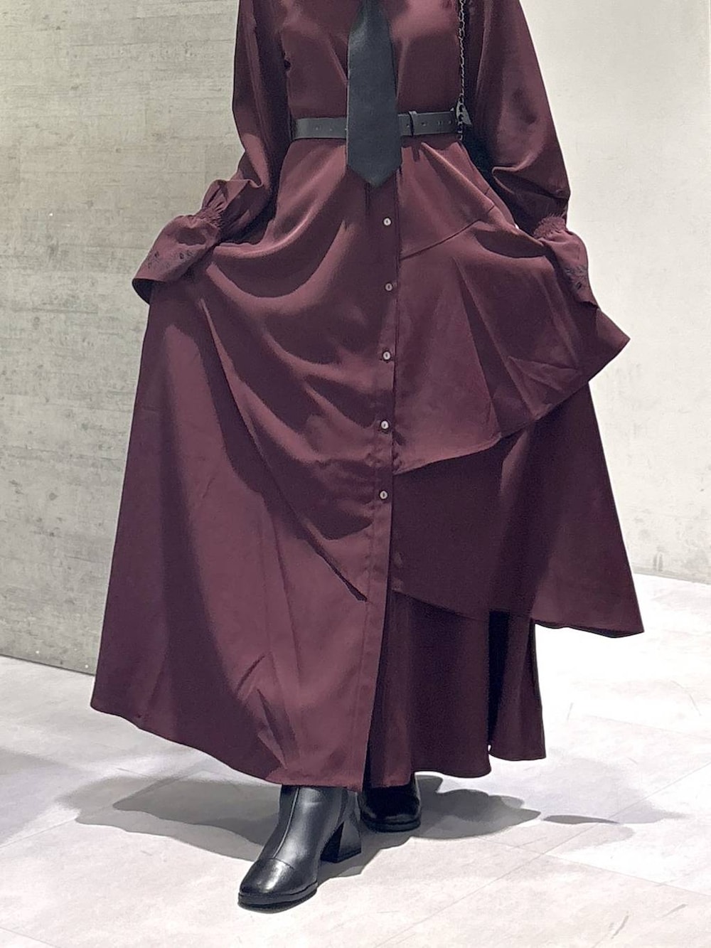 ブラック系のネクタイ、グレー系のタンクトップ、ブラック系のブーツを着用したレディースの秋コーディネートの3枚目の写真