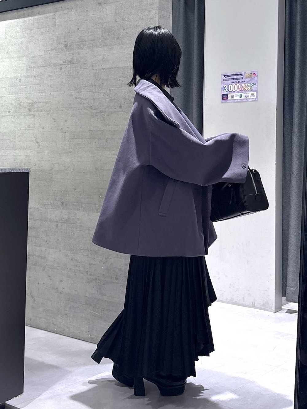 パープル系のチェスターコート、ブラック系のボストンバッグ、ブラック系のブーツを着用したレディースの冬コーディネートの6枚目の写真