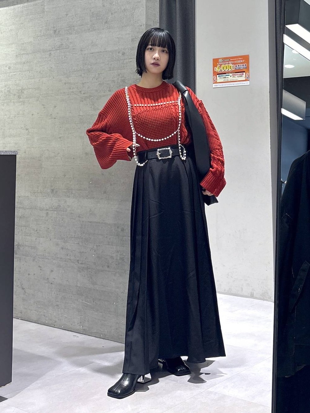 ブラック系のタンクトップ、ブラック系のトートバッグ、ブラック系のブーツを着用したレディースの秋コーディネートの5枚目の写真