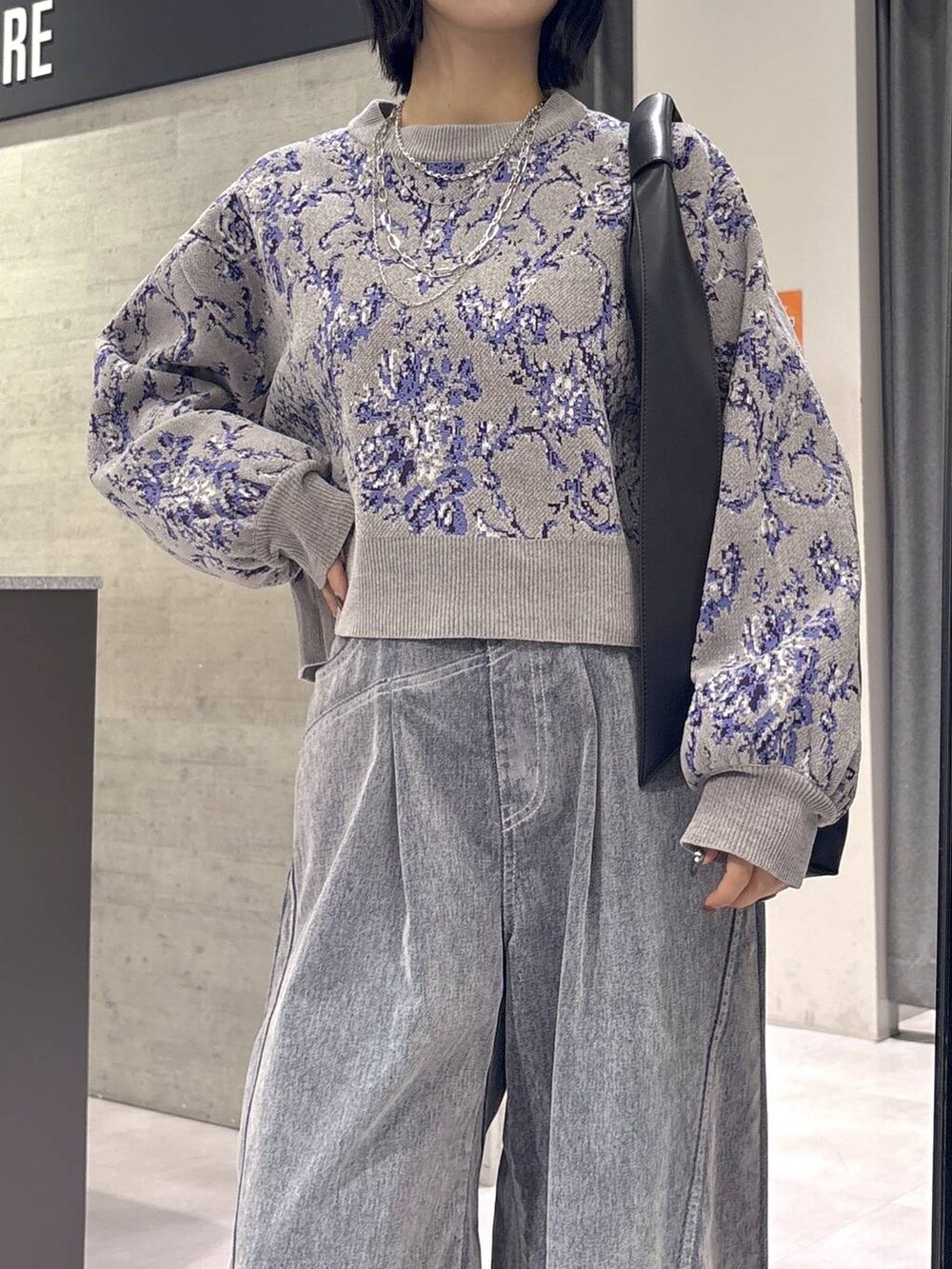 グレー系のタンクトップ、ブラック系のトートバッグ、グレー系のブーツを着用したレディースの秋コーディネートの2枚目の写真