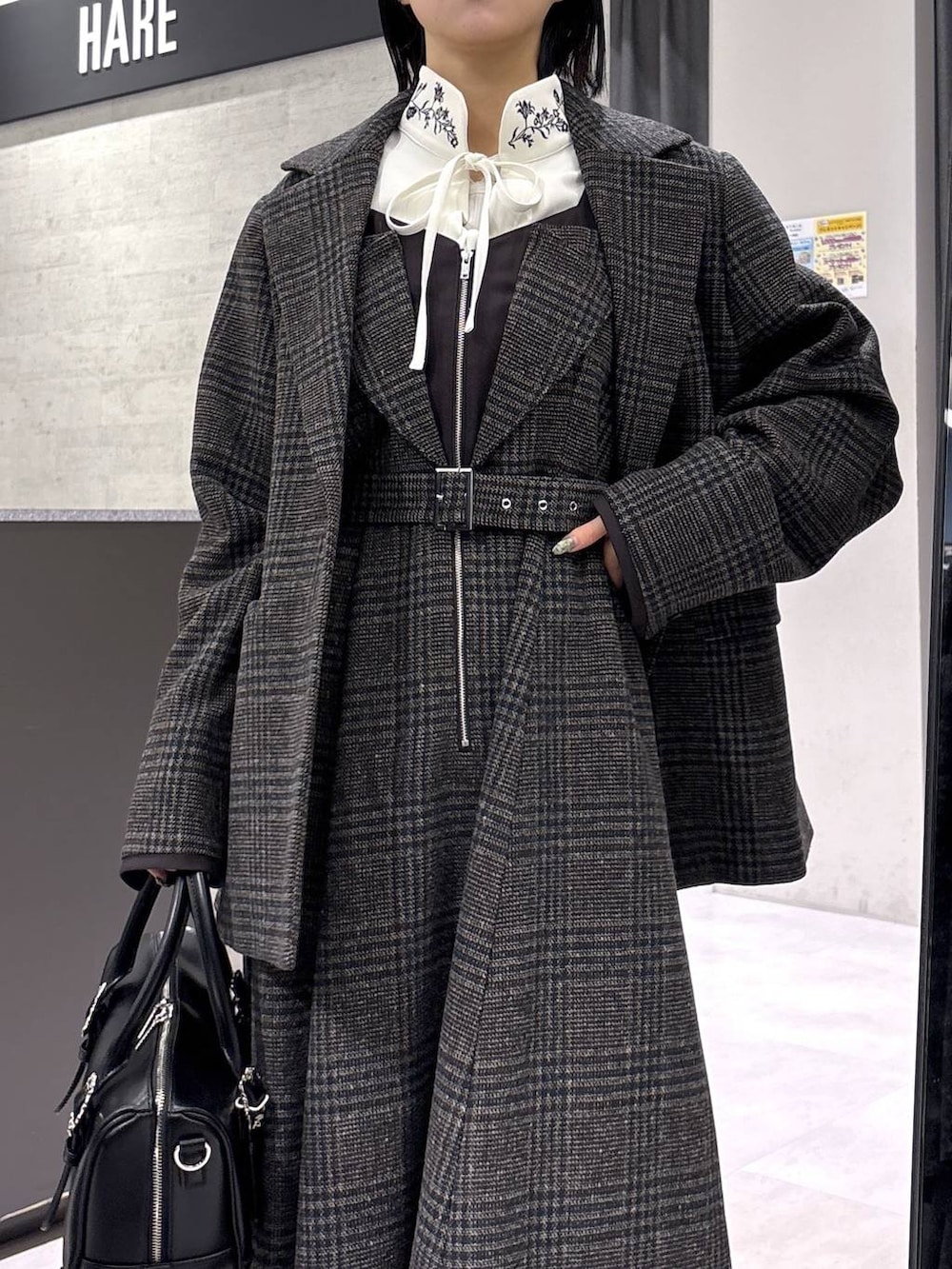 ホワイト系のタンクトップ、ブラック系のボストンバッグ、ホワイト系のシャツ/ブラウスを着用したレディースの秋コーディネートの2枚目の写真