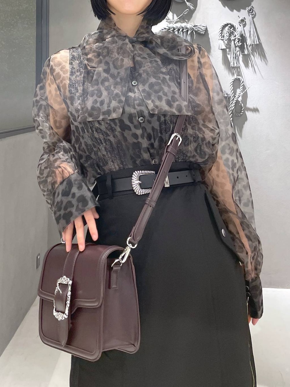 ブラック系のタンクトップ、ブラック系のサンダル、ブラウン系のショルダーバッグを着用したレディースの夏コーディネートの2枚目の写真