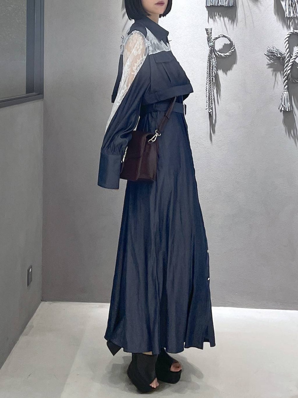 ブラック系のタンクトップ、ブラック系のサンダル、ブラウン系のショルダーバッグを着用したレディースの夏コーディネートの4枚目の写真