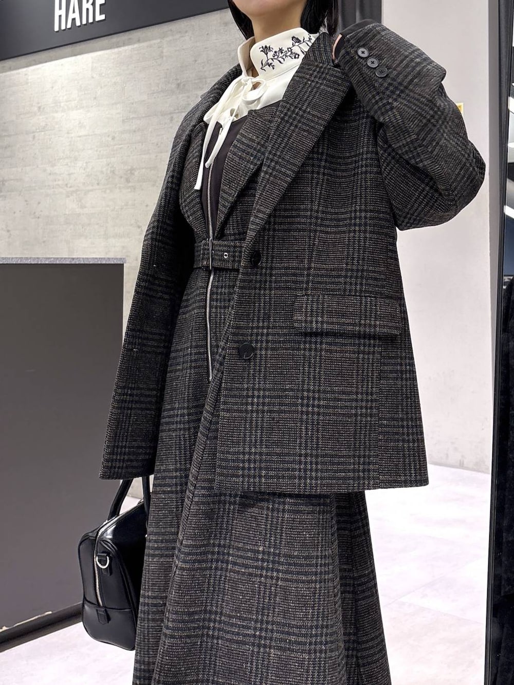 ホワイト系のタンクトップ、ブラック系のボストンバッグ、ホワイト系のシャツ/ブラウスを着用したレディースの秋コーディネートの8枚目の写真