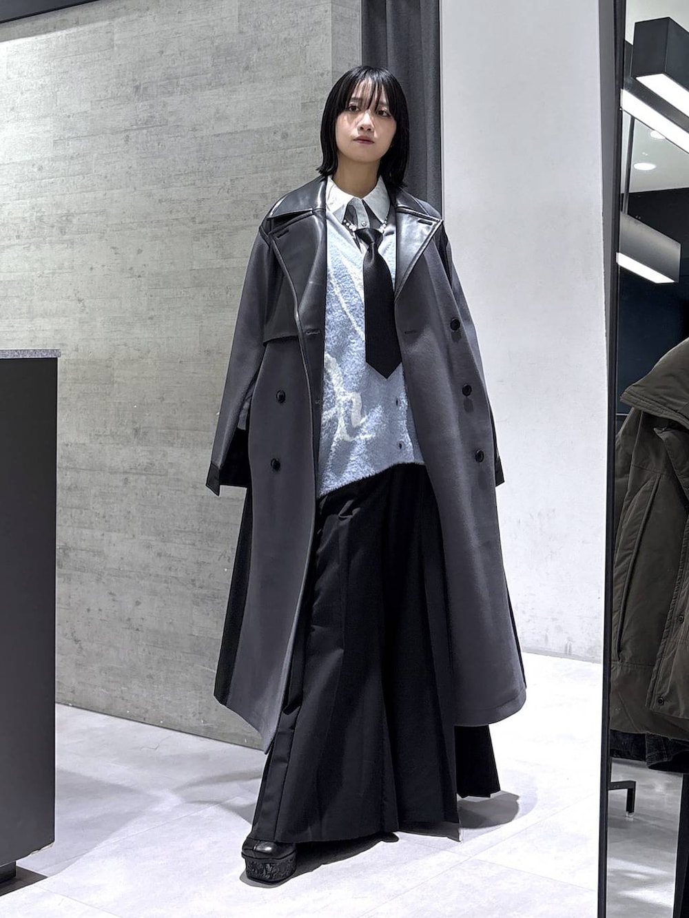 ブラック系のネクタイ、グレー系のタンクトップ、グレー系のブーツを着用したレディースの秋コーディネートの5枚目の写真