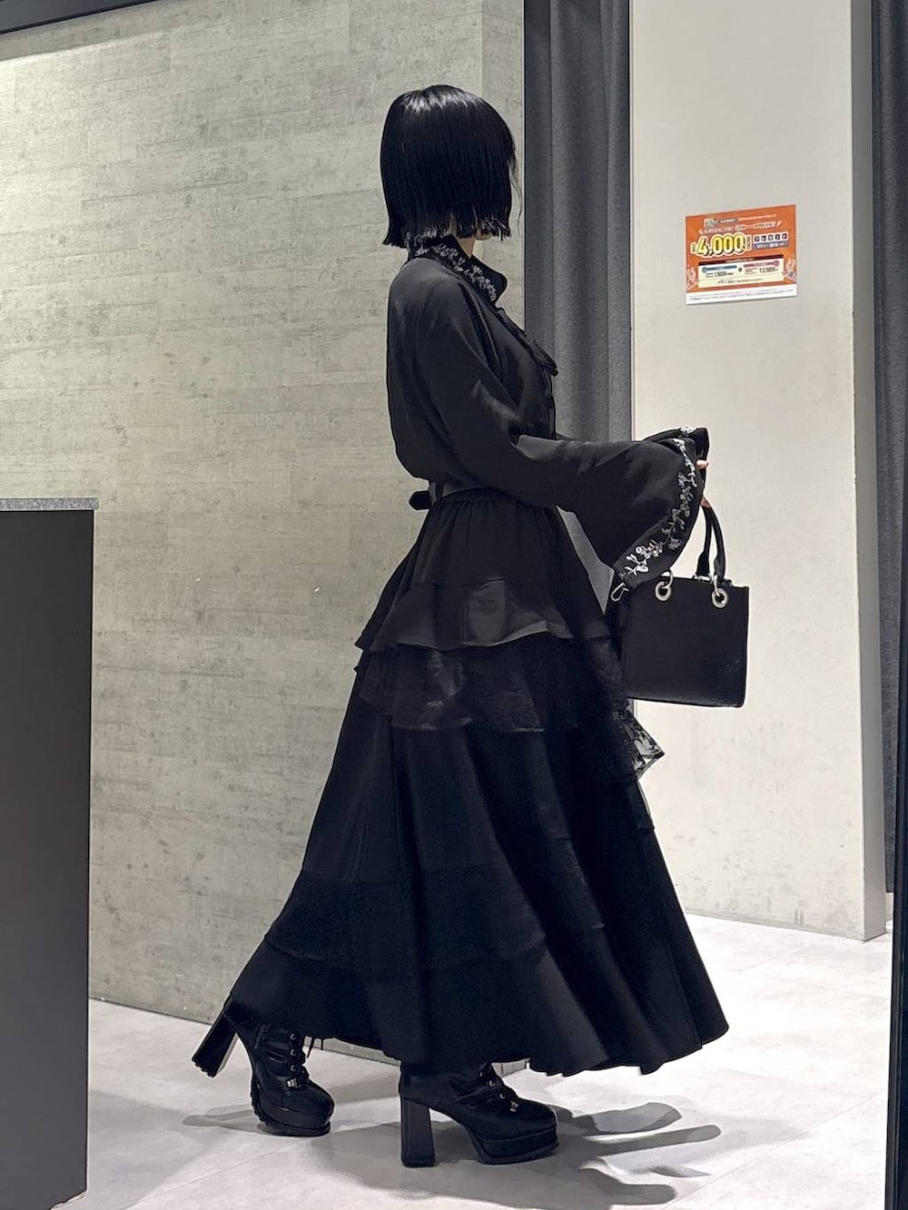 ブラック系のショルダーバッグ、ブラック系のシャツ/ブラウス、ブラック系のブーツを着用したレディースの秋コーディネートの6枚目の写真