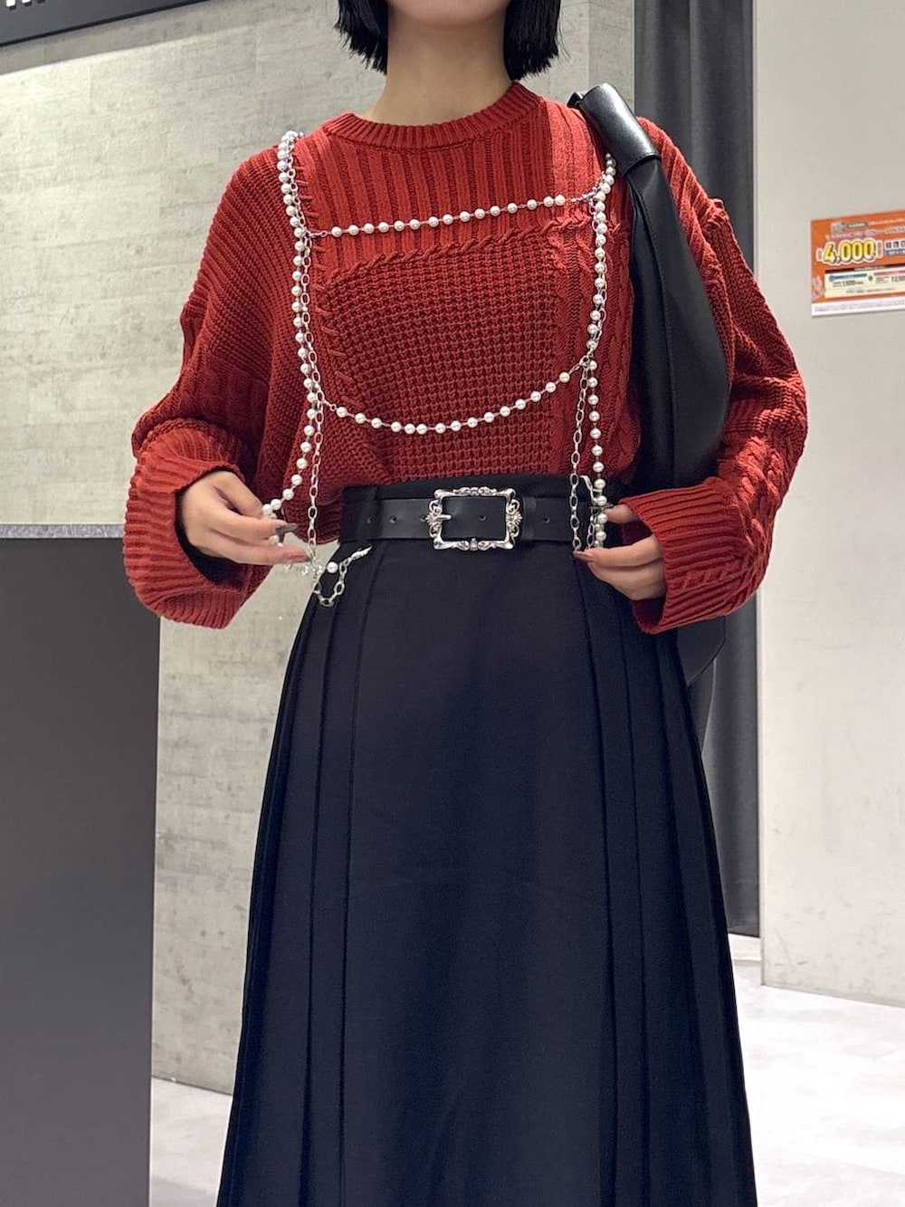 ブラック系のタンクトップ、ブラック系のトートバッグ、ブラック系のブーツを着用したレディースの秋コーディネートの2枚目の写真